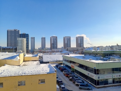 Зимний городской пейзаж с высотками на фоне ясного неба