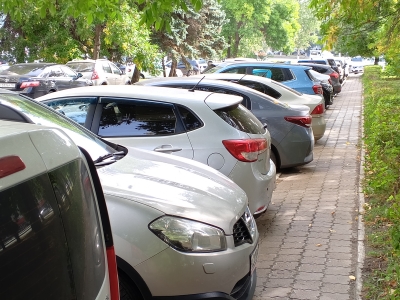 Автомобили, припаркованные вдоль тротуара