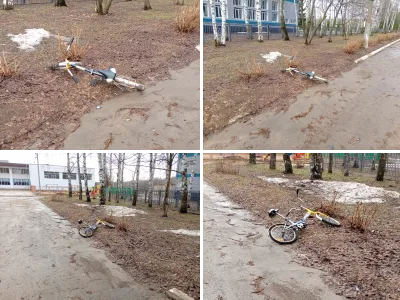 Детский велосипед лежит у дороги